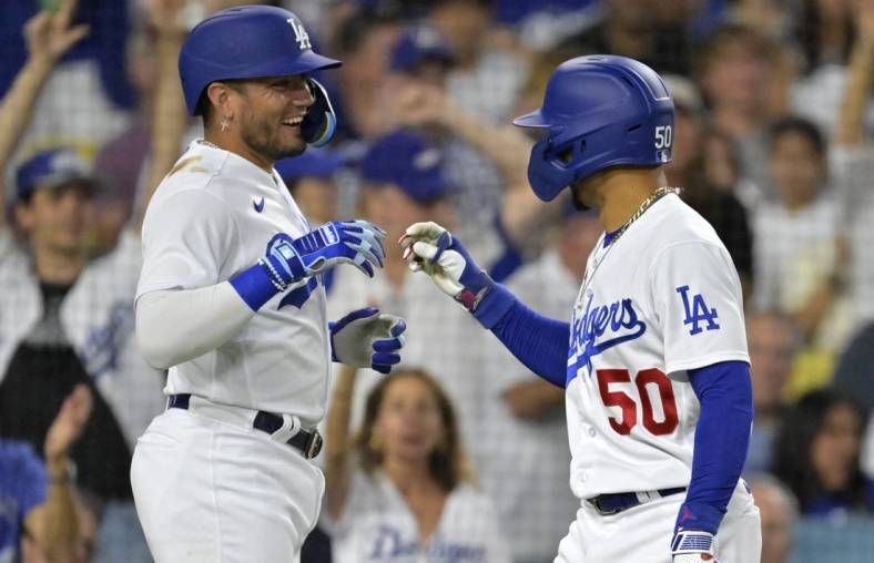 Aug 2, 2023; Los Angeles, California, USA;  Los Angeles Dodgers shortstop Miguel Rojas (11)  is greeted by right fielder Mookie Betts (50) after hitting a solo home run in the third inning against the Oakland Athletics at Dodger Stadium. Mandatory Credit: Jayne Kamin-Oncea-USA TODAY Sports