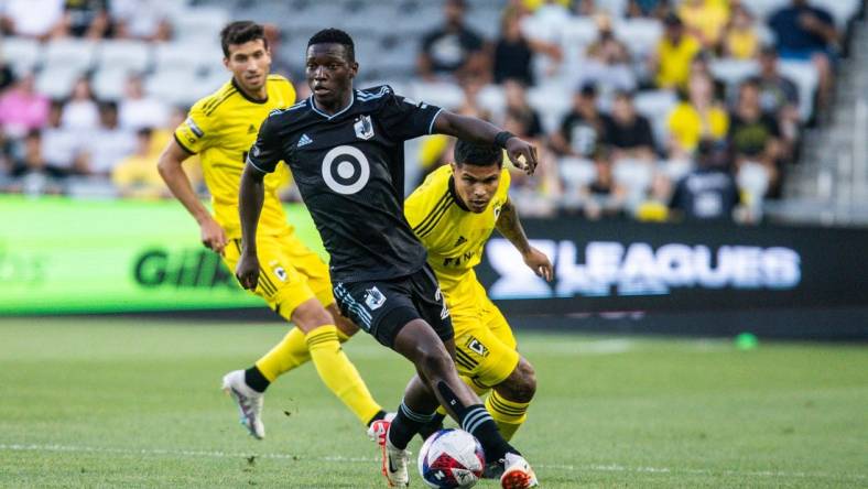 Aug 4, 2023; Columbus, OH, USA;  Minnesota United forward Bongokuhle Hlongwane (21) dribbles the ball while Columbus Crew forward Cucho Hernandez (9) defends in the first half at Lower.com Field. Mandatory Credit: Trevor Ruszkowski-USA TODAY Sports