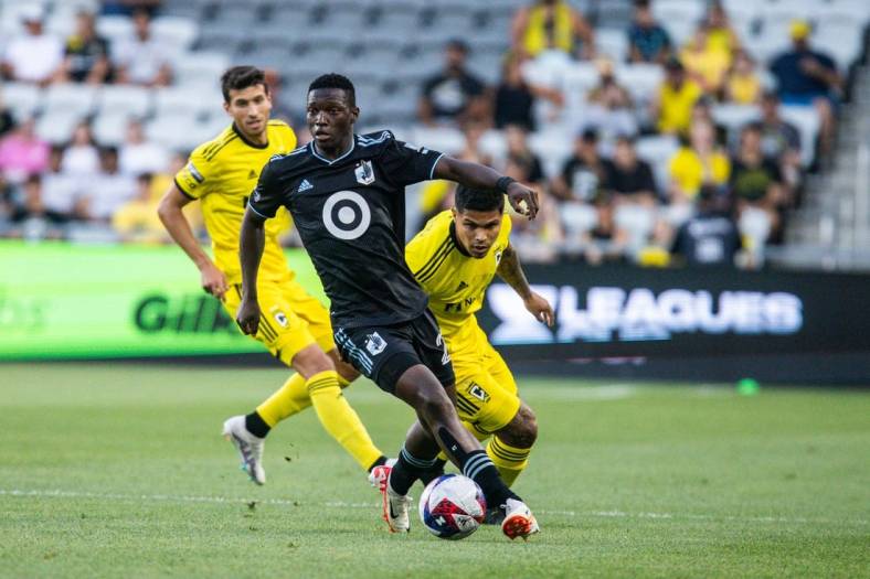 Aug 4, 2023; Columbus, OH, USA;  Minnesota United forward Bongokuhle Hlongwane (21) dribbles the ball while Columbus Crew forward Cucho Hernandez (9) defends in the first half at Lower.com Field. Mandatory Credit: Trevor Ruszkowski-USA TODAY Sports