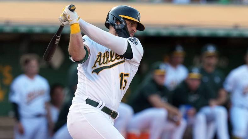 Aug 5, 2023; Oakland, California, USA; Oakland Athletics right fielder Seth Brown (15) hits an RBI single against the San Francisco Giants during the eighth inning at Oakland-Alameda County Coliseum. Mandatory Credit: Darren Yamashita-USA TODAY Sports