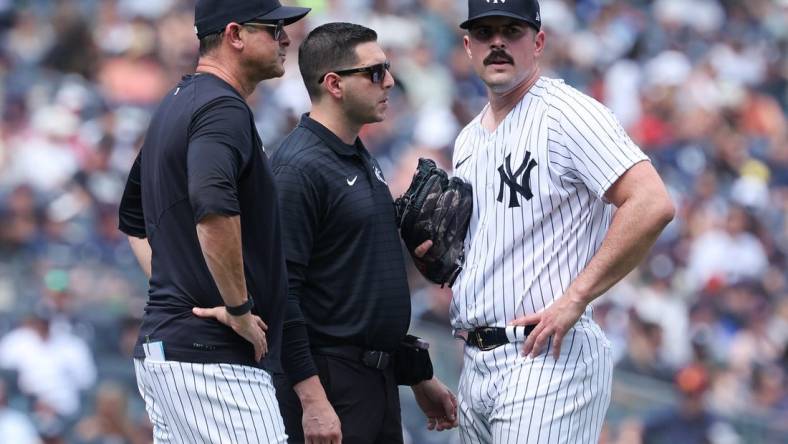 Aug 6, 2023; Bronx, New York, USA; New York Yankees starting pitcher Carlos Rodon (55) talks with medical staff and manager Aaron Boone (17) after an injury during the third inning against the Houston Astros at Yankee Stadium. Mandatory Credit: Vincent Carchietta-USA TODAY Sports