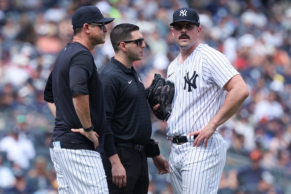 Aug 6, 2023; Bronx, New York, USA; New York Yankees starting pitcher Carlos Rodon (55) talks with medical staff and manager Aaron Boone (17) after an injury during the third inning against the Houston Astros at Yankee Stadium. Mandatory Credit: Vincent Carchietta-USA TODAY Sports