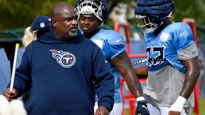 Tennessee Titans defensive line coach Terrell Williams walks with Shakel Brown, center, and Jayden Peevy, right, before starting the next drill during an NFL football training camp practice Tuesday, August 8, 2023, in Nashville, Tenn. Williams will be the Titans head coach for the preseason opener against the Chicago Bears.