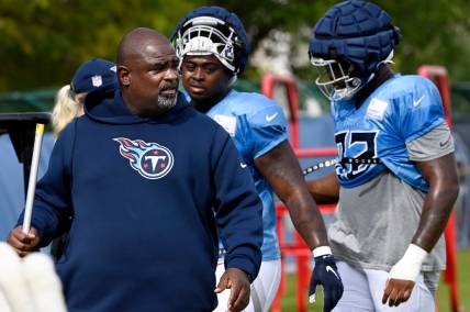 Tennessee Titans defensive line coach Terrell Williams walks with Shakel Brown, center, and Jayden Peevy, right, before starting the next drill during an NFL football training camp practice Tuesday, August 8, 2023, in Nashville, Tenn. Williams will be the Titans head coach for the preseason opener against the Chicago Bears.