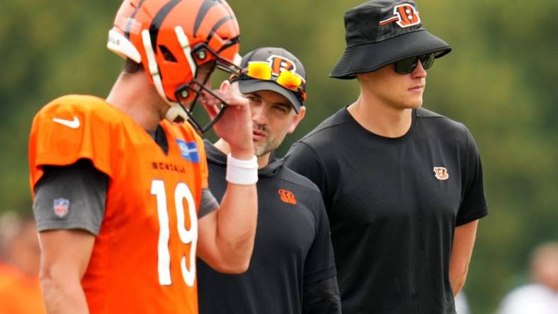 Cincinnati Bengals quarterback Joe Burrow (9), far right, observes play alongside Cincinnati Bengals quarterback Trevor Siemian (19), far left, and quarterbacks coach Dan Pitcher during a joint practice between the Green Bay Packers and the Cincinnati Bengals, Wednesday, Aug. 9, 2023, at the practice fields next to Paycor Stadium in Cincinnati.