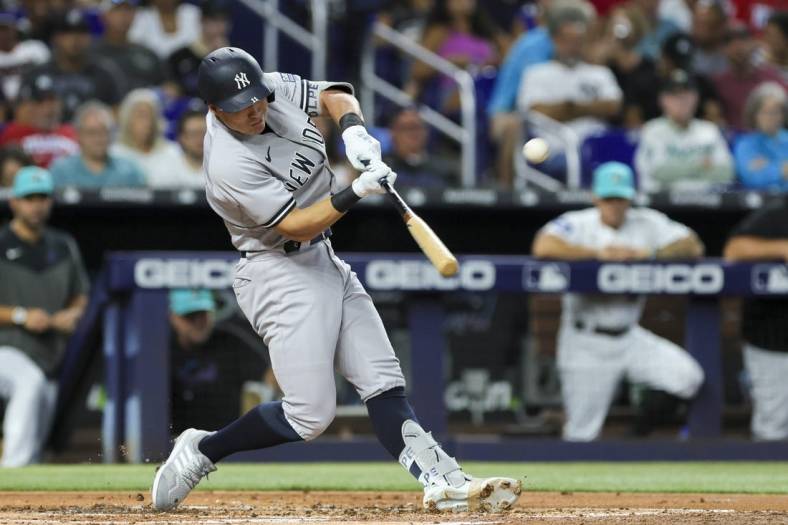 Aug 11, 2023; Miami, Florida, USA; New York Yankees shortstop Anthony Volpe (11) hits a three-run home run against the Miami Marlins during the second inning at loanDepot Park. Mandatory Credit: Sam Navarro-USA TODAY Sports