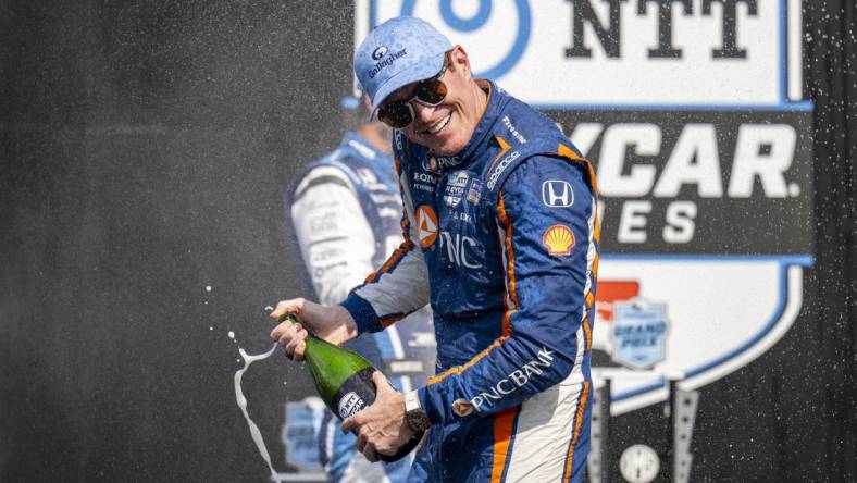 Aug 12, 2023; Speedway, Indiana, USA; Chip Ganassi Racing driver Scott Dixon (9) turns away from Rahal Letterman Lanigan Racing driver Graham Rahal (15) during the champagne fight on the podium after the Gallagher Grand Prix at the Indianapolis Motor Speedway Road Course. Mandatory Credit: Marc Lebryk-USA TODAY Sports