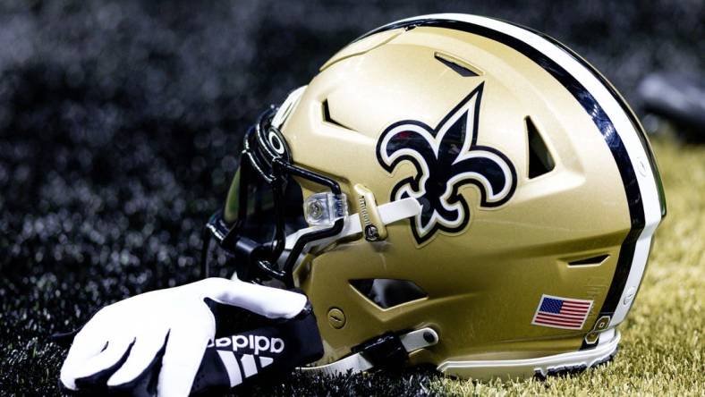 Aug 13, 2023; New Orleans, Louisiana, USA;  Detailed view of the New Orleans Saints helmet and glove during pregame against the Kansas City Chiefs at the Caesars Superdome. Mandatory Credit: Stephen Lew-USA TODAY Sports