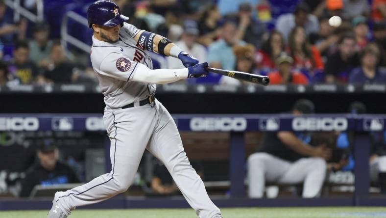 Aug 15, 2023; Miami, Florida, USA; Houston Astros catcher Yainer Diaz (21) hits a two-run home run against the Miami Marlins during the fourth inning at loanDepot Park. Mandatory Credit: Sam Navarro-USA TODAY Sports