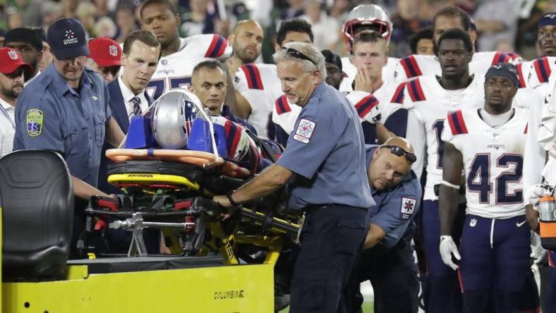 Aug 19, 2023; Green Bay, WI, USA;   Teammates look on as New England Patriots cornerback Isaiah Bolden (7) is taken off the field on a stretcher after a fourth quarter injury against the Green Bay Packers during their preseason football game at Lambeau Field. The game was suspended in the fourth quarter after the injury. Mandatory Credit: Dan Powers-USA TODAY Sports