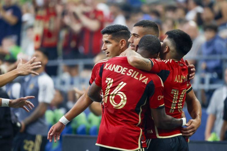 Aug 20, 2023; Seattle, Washington, USA; Atlanta United forward Giorgos Giakoumakis (7, second from left) celebrates with defender Luis Abram (4, left), forward Xande Silva (16) and midfielder Luiz Araujo (10) after scoring a goal against the Seattle Sounders FC during the first half at Lumen Field. Mandatory Credit: Joe Nicholson-USA TODAY Sports