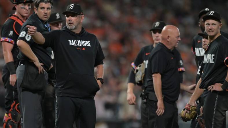 Aug 25, 2023; Baltimore, Maryland, USA;  Baltimore Orioles manager Brandon Hyde (18) signals to the dugout after relief pitcher Felix Bautista (74) slipped on the pitcher's mound during the ninth inning against the Colorado Rockies at Oriole Park at Camden Yards. Mandatory Credit: Tommy Gilligan-USA TODAY Sports