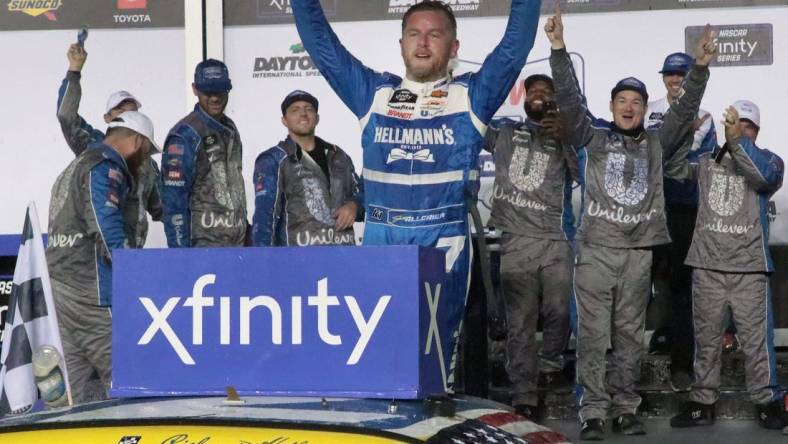 Justin Allgaier stands on his no. 7 Chevrolet in Victory Lane, Friday night August 25, 2023 after winning the Wawa 250 at Daytona International Speedway.