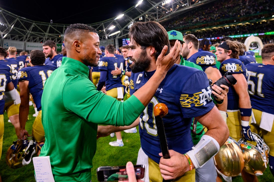 Aug 26, 2023; Dublin, IRL; Notre Dame Fighting Irish head coach Marcus Freeman, left, celebrates with quarterback Sam Hartman (10) after Notre Dame defeated the Navy Midshipmen 42-3 at Aviva Stadium. Mandatory Credit: Matt Cashore-USA TODAY Sports