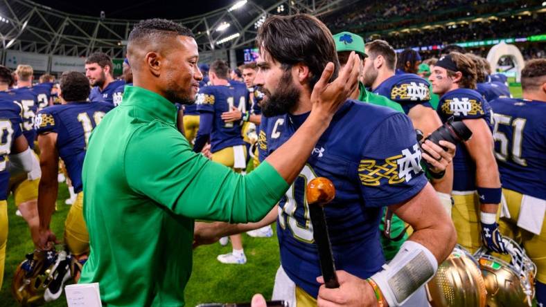 Aug 26, 2023; Dublin, IRL; Notre Dame Fighting Irish head coach Marcus Freeman, left, celebrates with quarterback Sam Hartman (10) after Notre Dame defeated the Navy Midshipmen 42-3 at Aviva Stadium. Mandatory Credit: Matt Cashore-USA TODAY Sports