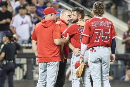 Aug 26, 2023; New York City, New York, USA;  Los Angeles Angels starting pitcher Chase Silseth (63) is checked on after getting hit in the head by a throw in the fourth inning against the New York Mets at Citi Field. Mandatory Credit: Wendell Cruz-USA TODAY Sports
