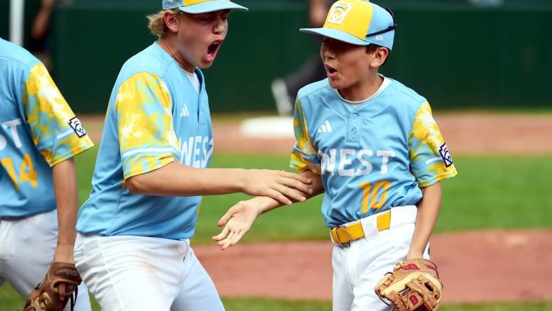 Aug 27, 2023; Williamsport, PA, USA; West Region second baseman Colby Lee (10) is congratulated by first baseman Jaxon Kalish (22) after turning a double play in the second inning against the Caribbean Region at Lamade Stadium. Mandatory Credit: Evan Habeeb-USA TODAY Sports