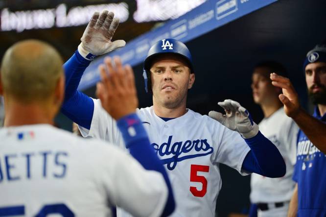 Aug 28, 2023; Los Angeles, California, USA; Los Angeles Dodgers first baseman Freddie Freeman (5) is greeted after hitting a solo home run against the Arizona Diamondbacks during the first inning at Dodger Stadium. Mandatory Credit: Gary A. Vasquez-USA TODAY Sports