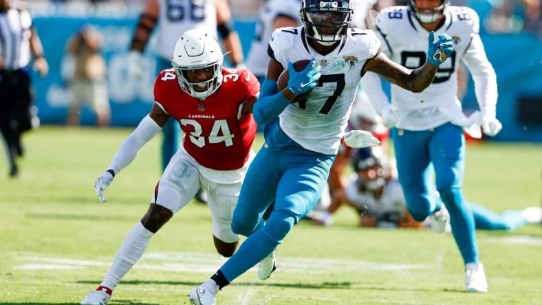 Sep 26, 2021; Jacksonville, Florida, USA;  Jacksonville Jaguars wide receiver D.J. Chark (17) runs with the ball while being chased by Arizona Cardinals defensive back Jalen Thompson (34) in the fourth quarter at TIAA Bank Field. Mandatory Credit: Nathan Ray Seebeck-USA TODAY Sports