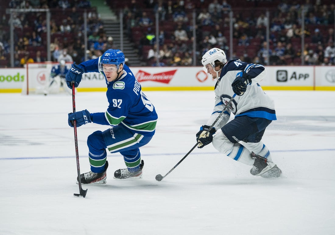 Oct 3, 2021; Vancouver, British Columbia, CAN;  Winnipeg Jets defenseman Declan Chisholm (47) checks Vancouver Canucks forward Vasily Podkolzin (92) in the second period at Rogers Arena. Mandatory Credit: Bob Frid-USA TODAY Sports