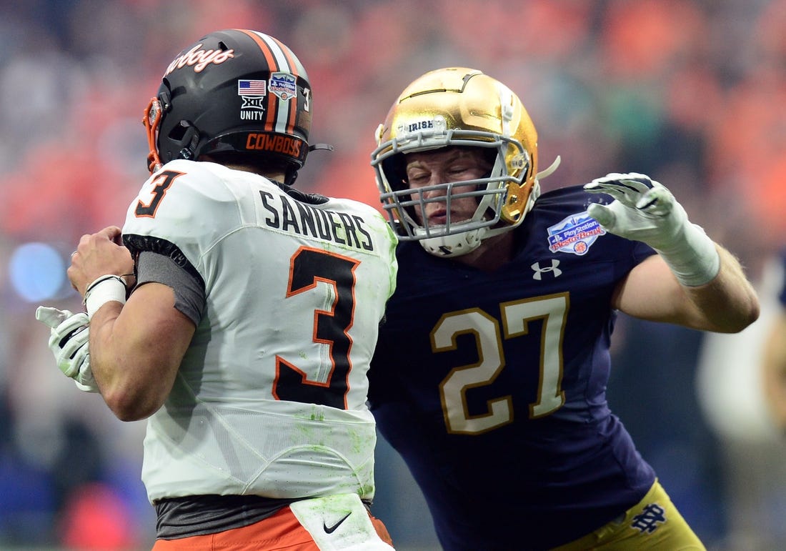 Jan 1, 2022; Glendale, Arizona, USA; Oklahoma State Cowboys quarterback Spencer Sanders (3) eludes the sack of Notre Dame Fighting Irish linebacker JD Bertrand (27) during the first half of the 2022 Fiesta Bowl at State Farm Stadium. Mandatory Credit: Joe Camporeale-USA TODAY Sports