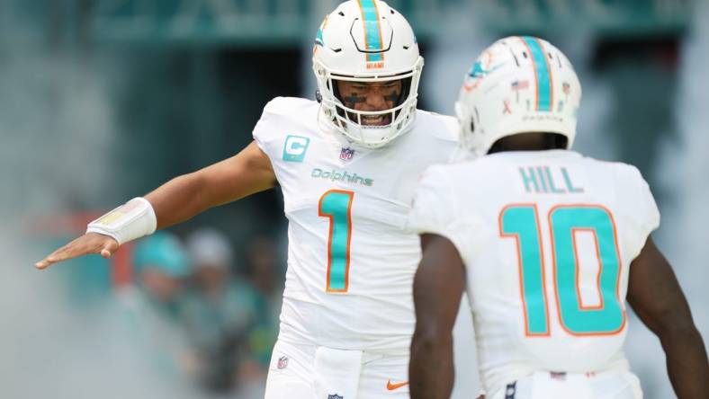 Miami Dolphins quarterback Tua Tagovailoa (1) and wide receiver Tyreek Hill (10) take the field before the opening game of the season against the New England Patriots at Hard Rock Stadium in Miami Gardens, Sept. 11, 2022.