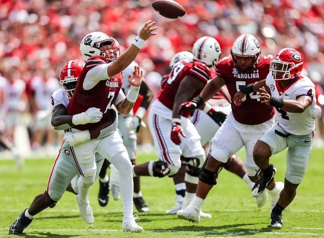 Sep 17, 2022; Columbia, South Carolina, USA; South Carolina Gamecocks quarterback Spencer Rattler (7) passes as he is hit by Georgia Bulldogs defensive lineman Mykel Williams (13) in the second quarter at Williams-Brice Stadium. Mandatory Credit: Jeff Blake-USA TODAY Sports