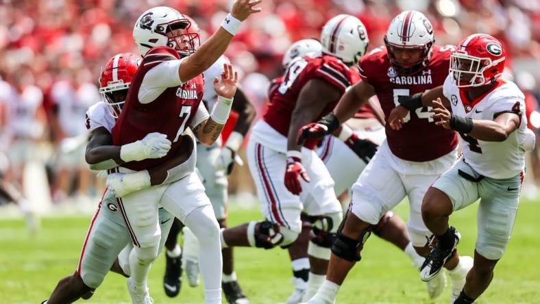 Sep 17, 2022; Columbia, South Carolina, USA; South Carolina Gamecocks quarterback Spencer Rattler (7) passes as he is hit by Georgia Bulldogs defensive lineman Mykel Williams (13) in the second quarter at Williams-Brice Stadium. Mandatory Credit: Jeff Blake-USA TODAY Sports