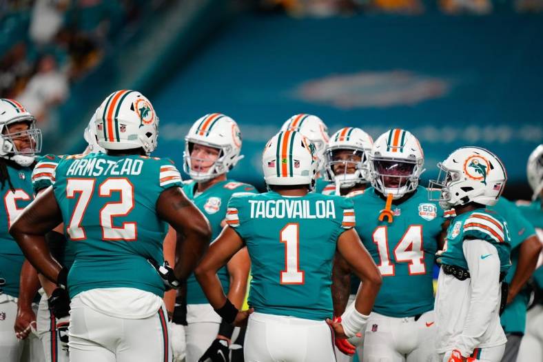 Oct 23, 2022; Miami Gardens, Florida, USA; Miami Dolphins offensive tackle Terron Armstead (72) and Miami Dolphins quarterback Tua Tagovailoa (1) talk to teammates prior to a game against the Pittsburgh Steelers at Hard Rock Stadium. Mandatory Credit: Rich Storry-USA TODAY Sports