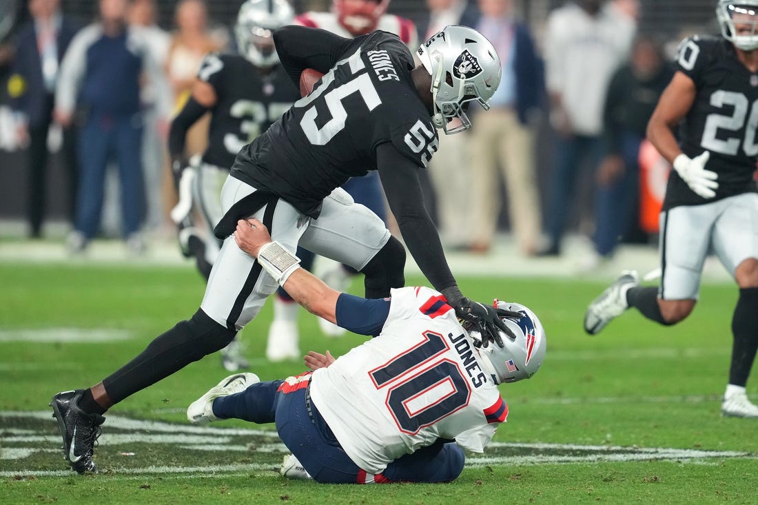 Dec 18, 2022; Paradise, Nevada, USA; Las Vegas Raiders defensive end Chandler Jones (55) stiff-arms New England Patriots quarterback Mac Jones (10) on the way to scoring a touchdown at the end of the second half at Allegiant Stadium. Mandatory Credit: Stephen R. Sylvanie-USA TODAY Sports