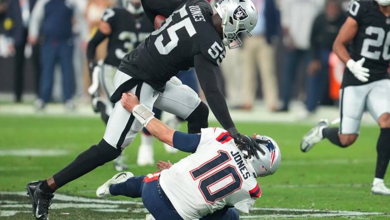 Dec 18, 2022; Paradise, Nevada, USA; Las Vegas Raiders defensive end Chandler Jones (55) stiff-arms New England Patriots quarterback Mac Jones (10) on the way to scoring a touchdown at the end of the second half at Allegiant Stadium. Mandatory Credit: Stephen R. Sylvanie-USA TODAY Sports