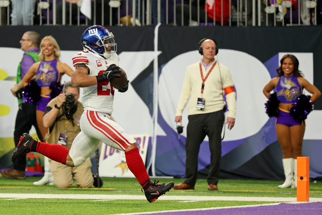 Jan 15, 2023; Minneapolis, Minnesota, USA; New York Giants running back Saquon Barkley (26) runs with the ball for a touchdown against the Minnesota Vikings during the first quarter of a wild card game at U.S. Bank Stadium. Mandatory Credit: Matt Krohn-USA TODAY Sports