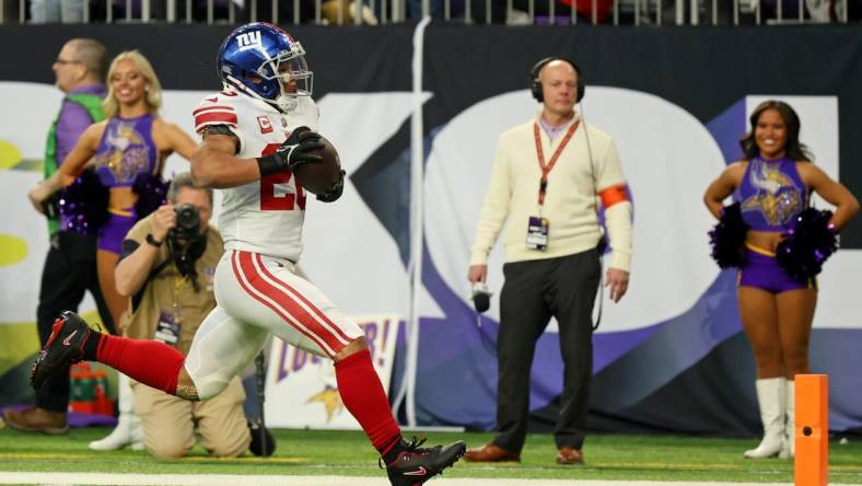 Jan 15, 2023; Minneapolis, Minnesota, USA; New York Giants running back Saquon Barkley (26) runs with the ball for a touchdown against the Minnesota Vikings during the first quarter of a wild card game at U.S. Bank Stadium. Mandatory Credit: Matt Krohn-USA TODAY Sports