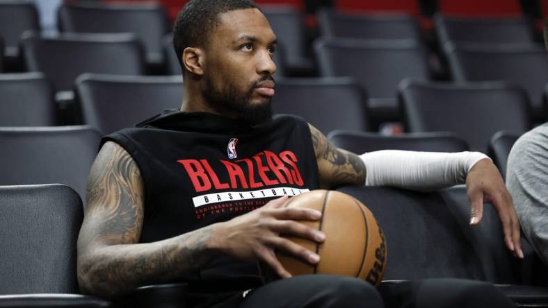 Mar 27, 2023; Portland, Oregon, USA; Portland Trail Blazers point guard Damian Lillard (0) watches players warm up prior to the game against the New Orleans Pelicans at Moda Center. Mandatory Credit: Soobum Im-USA TODAY Sports