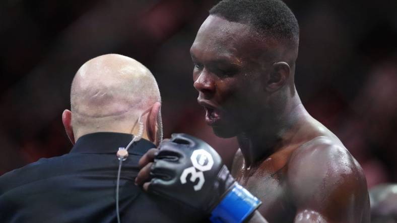Apr 8, 2023; Miami, Florida, USA; Israel Adesanya (blue gloves) reacts to defeating Alex Pereira (red gloves) during UFC 287 at Miami-Dade Arena. Mandatory Credit: Rich Storry-USA TODAY Sports