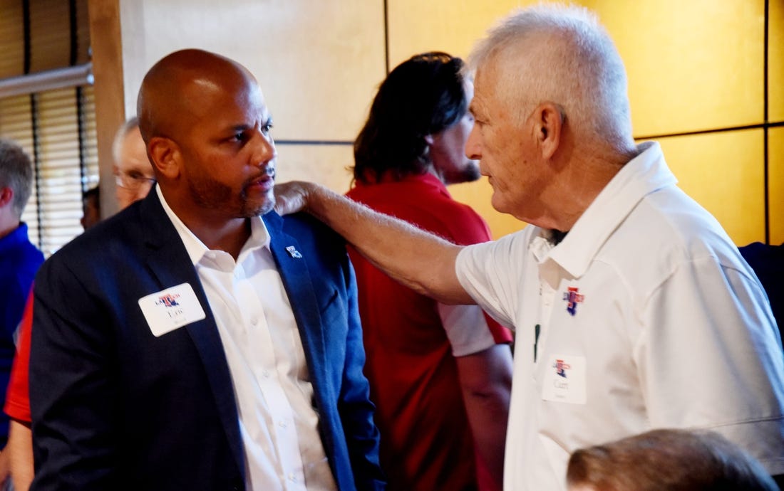 Louisiana Tech athletic director Eric Wood gets some advice from Curt Joiner during Tuesday's Bulldog Blitz at Shreveport's Cantina Laredo.