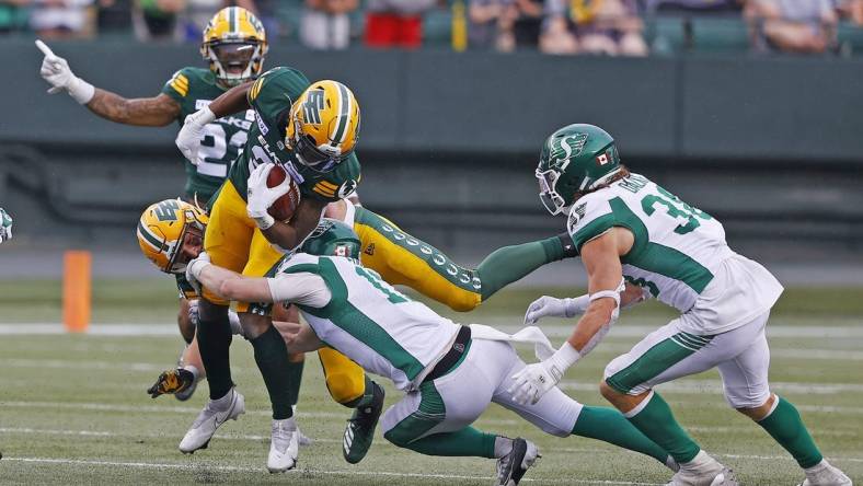 Jun 11, 2023; Edmonton, Alberta, CAN; Saskatchewan Roughriders defensive back Jaxon Ford (17) tackles Edmonton Elks running back Kevin Brown (4) during the second half at Commonwealth Stadium. Mandatory Credit: Perry Nelson-USA TODAY Sports