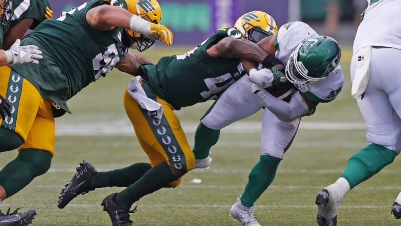 Jun 11, 2023; Edmonton, Alberta, CAN; Saskatchewan Roughriders running back Frankie Hickson (20) is tackled by Edmonton Elks linebacker Myles Morgan (45) during the second half at Commonwealth Stadium. Mandatory Credit: Perry Nelson-USA TODAY Sports