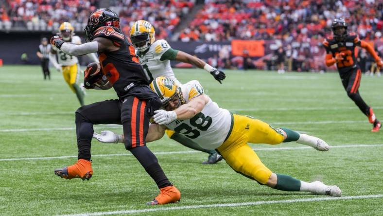 Jun 17, 2023; Vancouver, British Columbia, CAN; Edmonton Elks linebacker Konar Adam (38) tackles BC Lions running back Mizzell Taquan (25) in the second half at BC Place. BC won 22-0. Mandatory Credit: Bob Frid-USA TODAY Sports