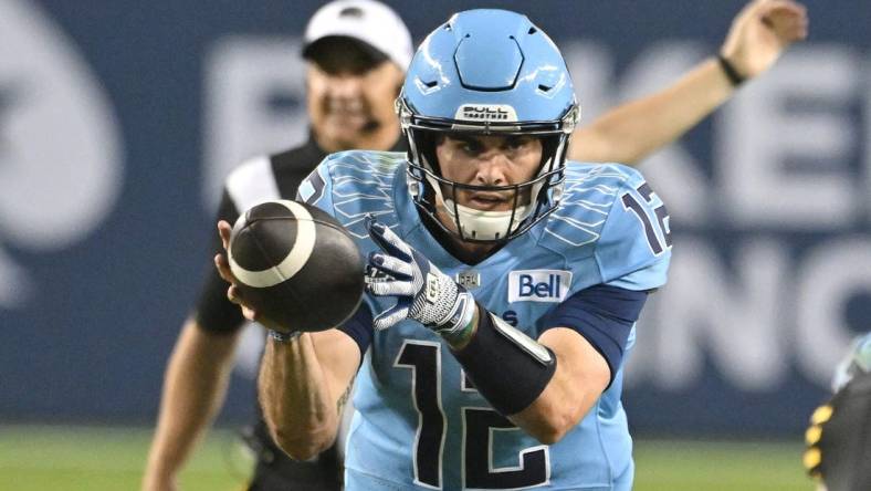 Jun 18, 2023; Toronto, Ontario, CAN;  Toronto Argonauts quarterback Chad Kelly (12) takes a snap in the fourth  quarter against the Hamilton Tiger-Cats at BMO Field. Mandatory Credit: Dan Hamilton-USA TODAY Sports