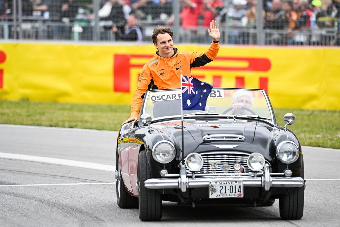 Jun 18, 2023; Montreal, Quebec, CAN; McLaren driver Oscar Piastri (AUS) parades and salutes the crowd before the Canadian Grand Prix at Circuit Gilles Villeneuve. Mandatory Credit: David Kirouac-USA TODAY Sports