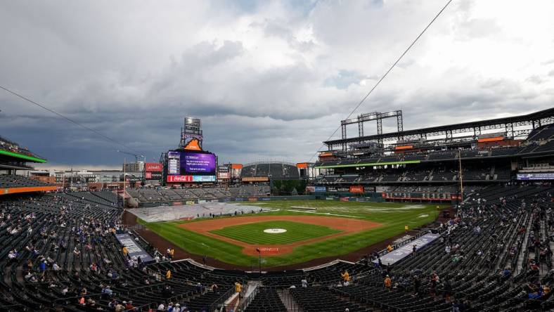 Jun 29, 2023; Denver, Colorado, USA; Grounds crew clear the infield tarp during a rain delay before the game between the Colorado Rockies and the Los Angeles Dodgers at Coors Field. Mandatory Credit: Isaiah J. Downing-USA TODAY Sports