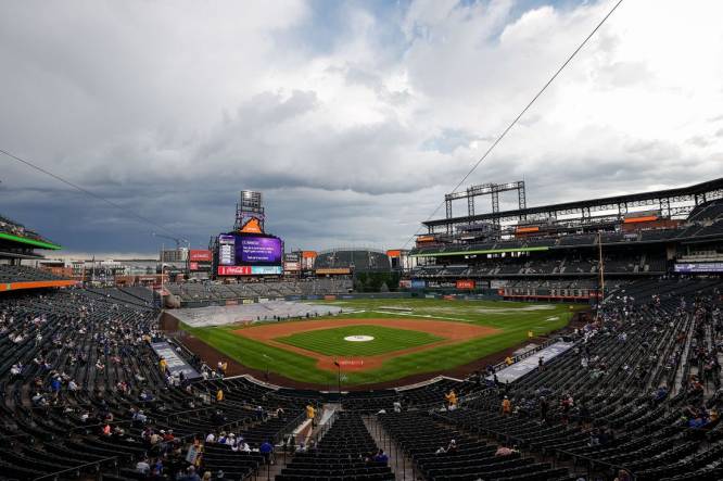 Jun 29, 2023; Denver, Colorado, USA; Grounds crew clear the infield tarp during a rain delay before the game between the Colorado Rockies and the Los Angeles Dodgers at Coors Field. Mandatory Credit: Isaiah J. Downing-USA TODAY Sports