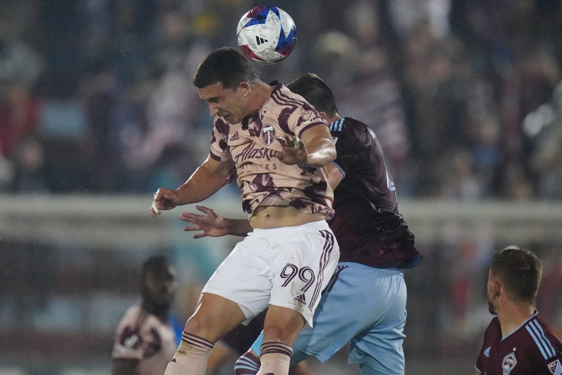 Jul 4, 2023; Commerce City, Colorado, USA; Portland Timbers forward Nathan Fogaca (99) heads the ball against Colorado Rapids defender Danny Wilson (4) during the first half at Dick's Sporting Goods Park. Mandatory Credit: Ron Chenoy-USA TODAY Sports