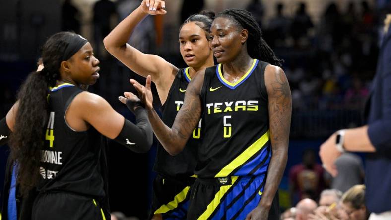 Jul 22, 2023; Arlington, Texas, USA; Dallas Wings guard Arike Ogunbowale (24) and forward Satou Sabally (0) and forward Natasha Howard (6) celebrate after they leave the game against the Los Angeles Sparks during the second half at College Park Center. Mandatory Credit: Jerome Miron-USA TODAY Sports