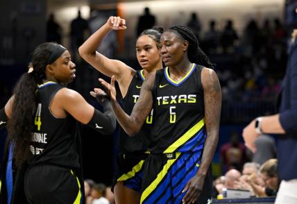 Jul 22, 2023; Arlington, Texas, USA; Dallas Wings guard Arike Ogunbowale (24) and forward Satou Sabally (0) and forward Natasha Howard (6) celebrate after they leave the game against the Los Angeles Sparks during the second half at College Park Center. Mandatory Credit: Jerome Miron-USA TODAY Sports