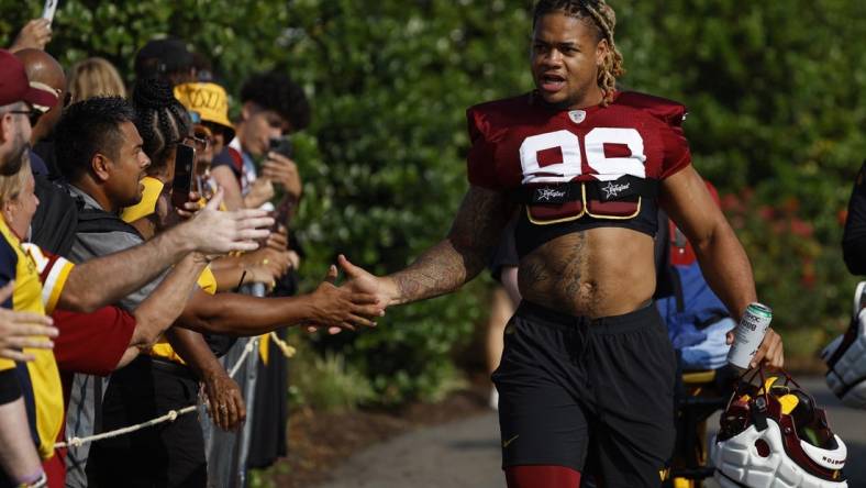 Jul 28, 2023; Ashburn, VA, USA; Washington Commanders defensive end Chase Young (99) shakes hands with fans while walking onto the fields prior to day three of Commanders training camp at OrthoVirginia Training Center. Mandatory Credit: Geoff Burke-USA TODAY Sports