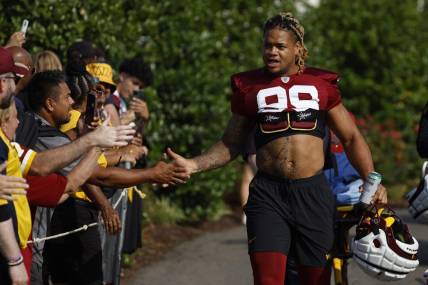 Jul 28, 2023; Ashburn, VA, USA; Washington Commanders defensive end Chase Young (99) shakes hands with fans while walking onto the fields prior to day three of Commanders training camp at OrthoVirginia Training Center. Mandatory Credit: Geoff Burke-USA TODAY Sports