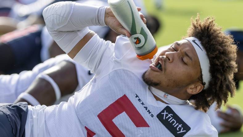 Jul 30, 2023; Houston, TX, USA; Houston Texans safety Jalen Pitre (5) takes a drink of water while warming up during training camp practice at the Houston Methodist Training Center. Mandatory Credit: Thomas Shea-USA TODAY Sports