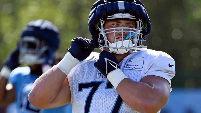 Tennessee Titans offensive tackle Peter Skoronski (77) puts on his helmet before an NFL football training camp practice Tuesday, August 1, 2023, in Nashville, Tenn.